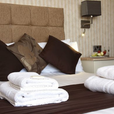 Double bed with cushions and towels neatly placed