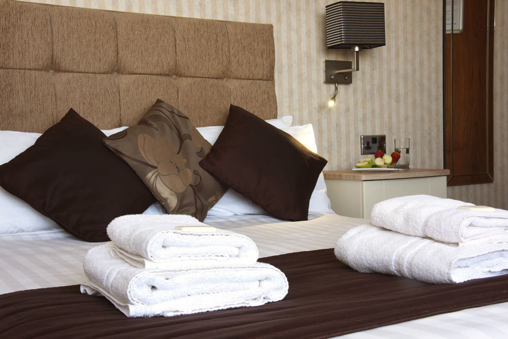Double bed with cushions and towels neatly placed